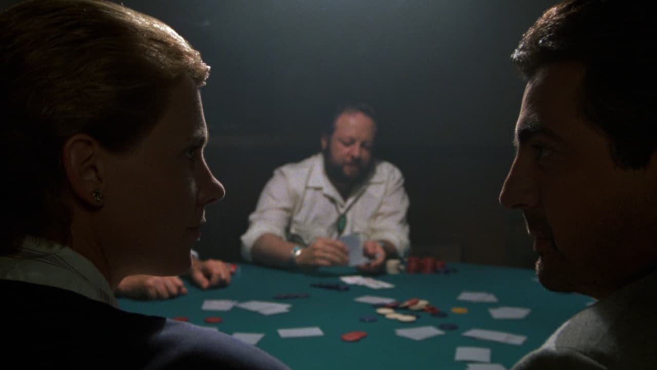 People sitting around a table playing poker while the protagonists stare at each other